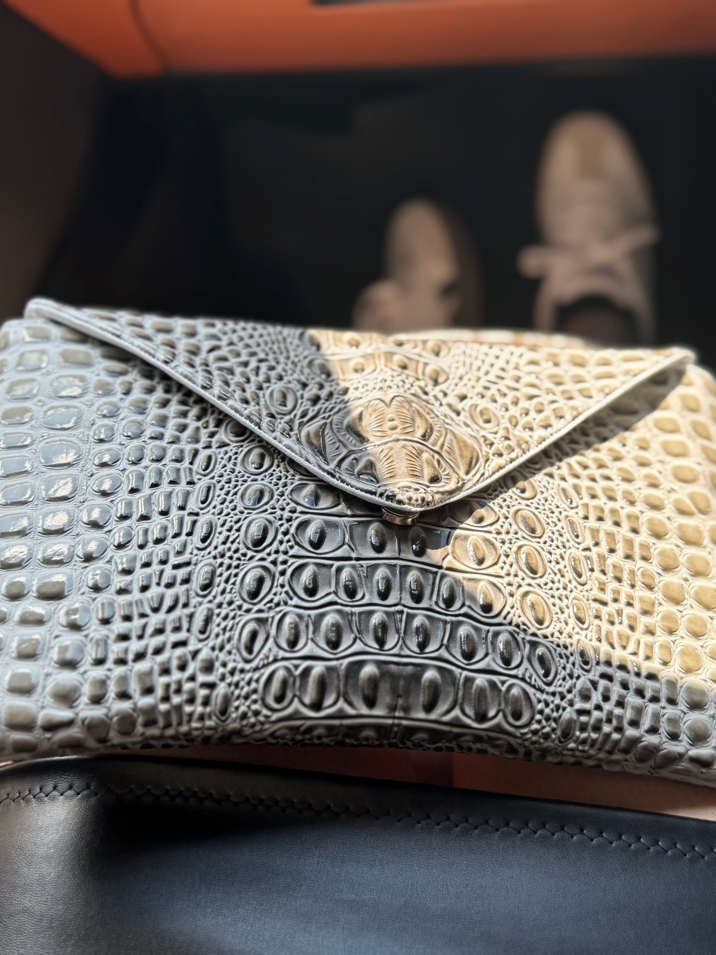 Envelope flap detail of gray croc vinyl crossbody bag showing texture and stitching